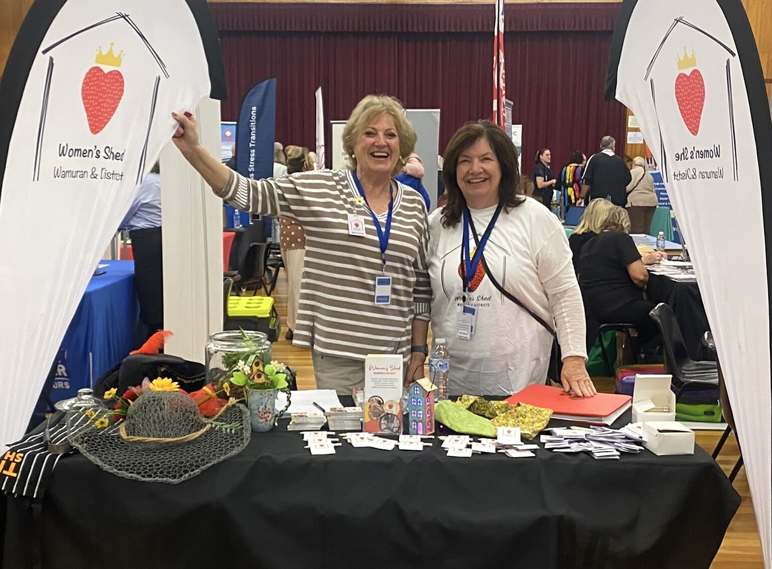 Two Women’s Shed exhibitors welcoming visitors at a Senior Expos Australia event
