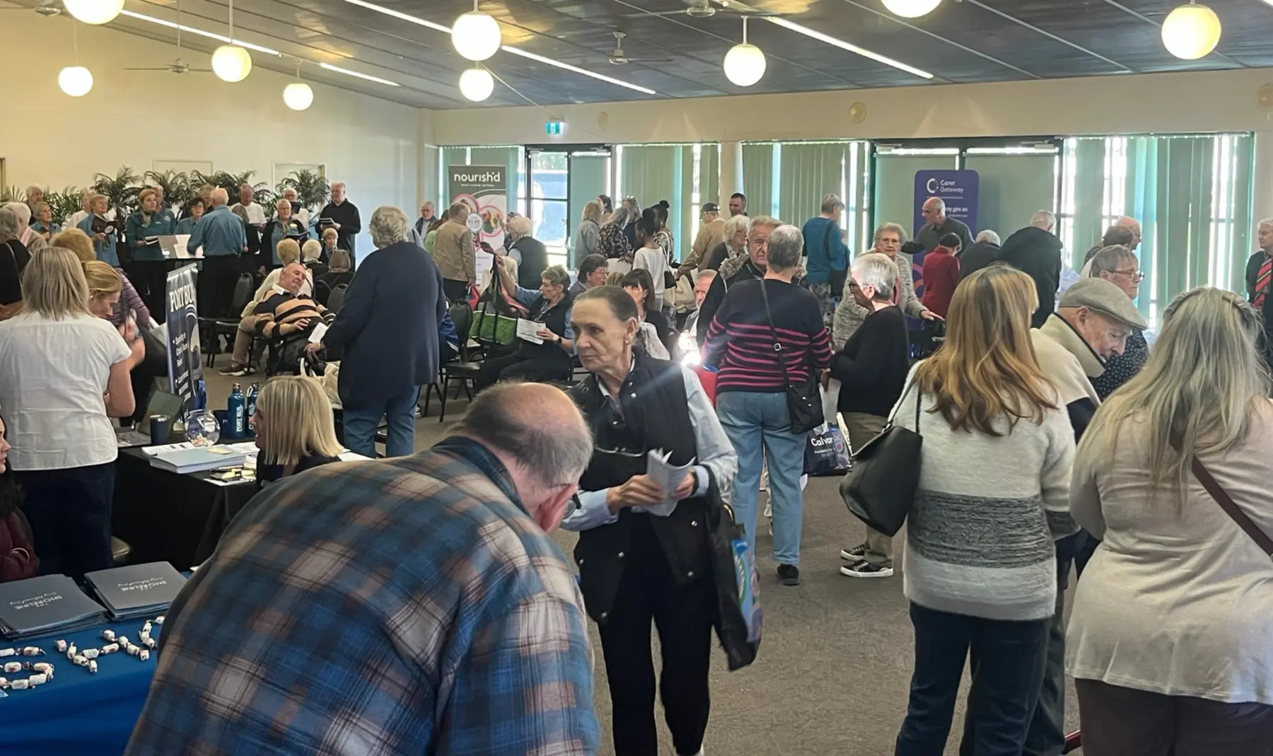 Older Australians talking with local service providers at a community expo